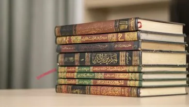 A stack of Islamic books including Quran and Hadith books